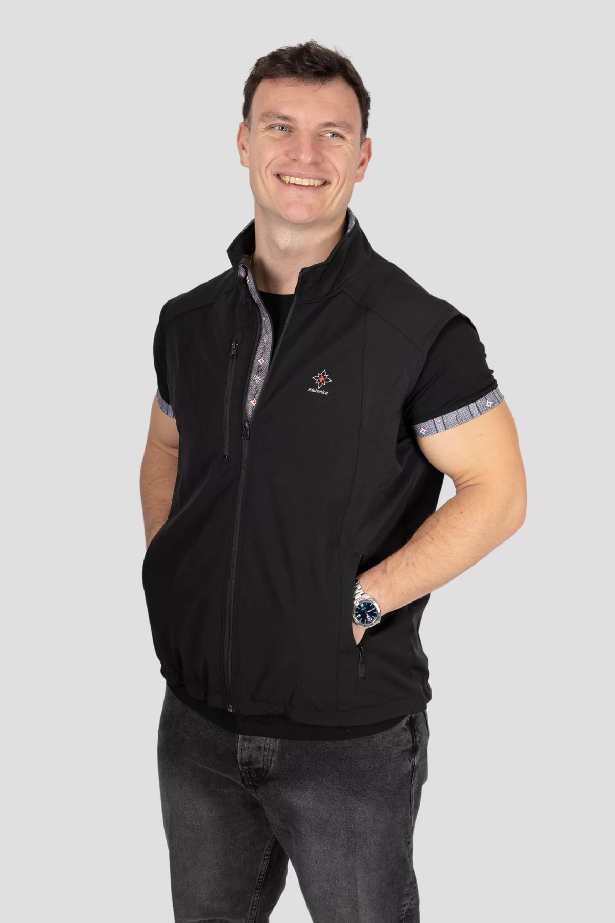 Softshell Gilet Edelweiss Herren von Edelvetica, schwarze Weste mit grauem Edelweiss-Muster, wind- und wasserdicht, stilvoll und funktional für Outdoor und Alltag.